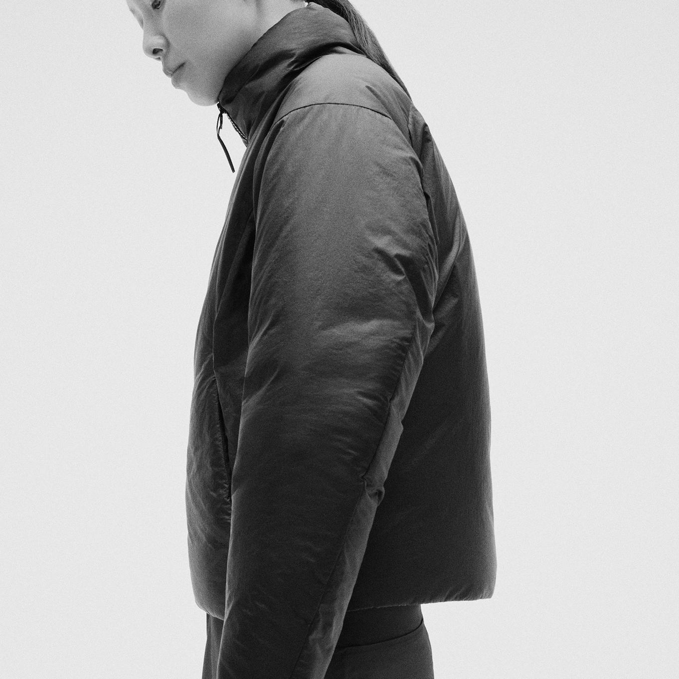 a black and white photo of a person wearing a black jacket .