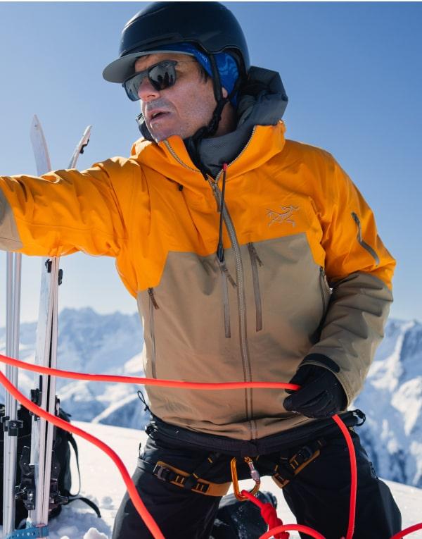 a man wearing a yellow jacket with the word arcteryx on it