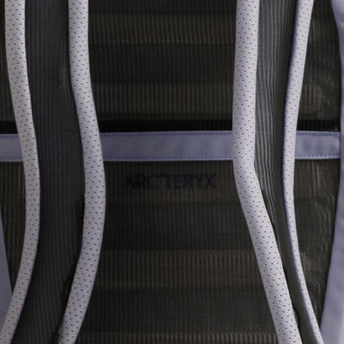 Close-up of a backpack's dark ribbed back panel with perforated light grey shoulder straps and the Arc'teryx logo.
