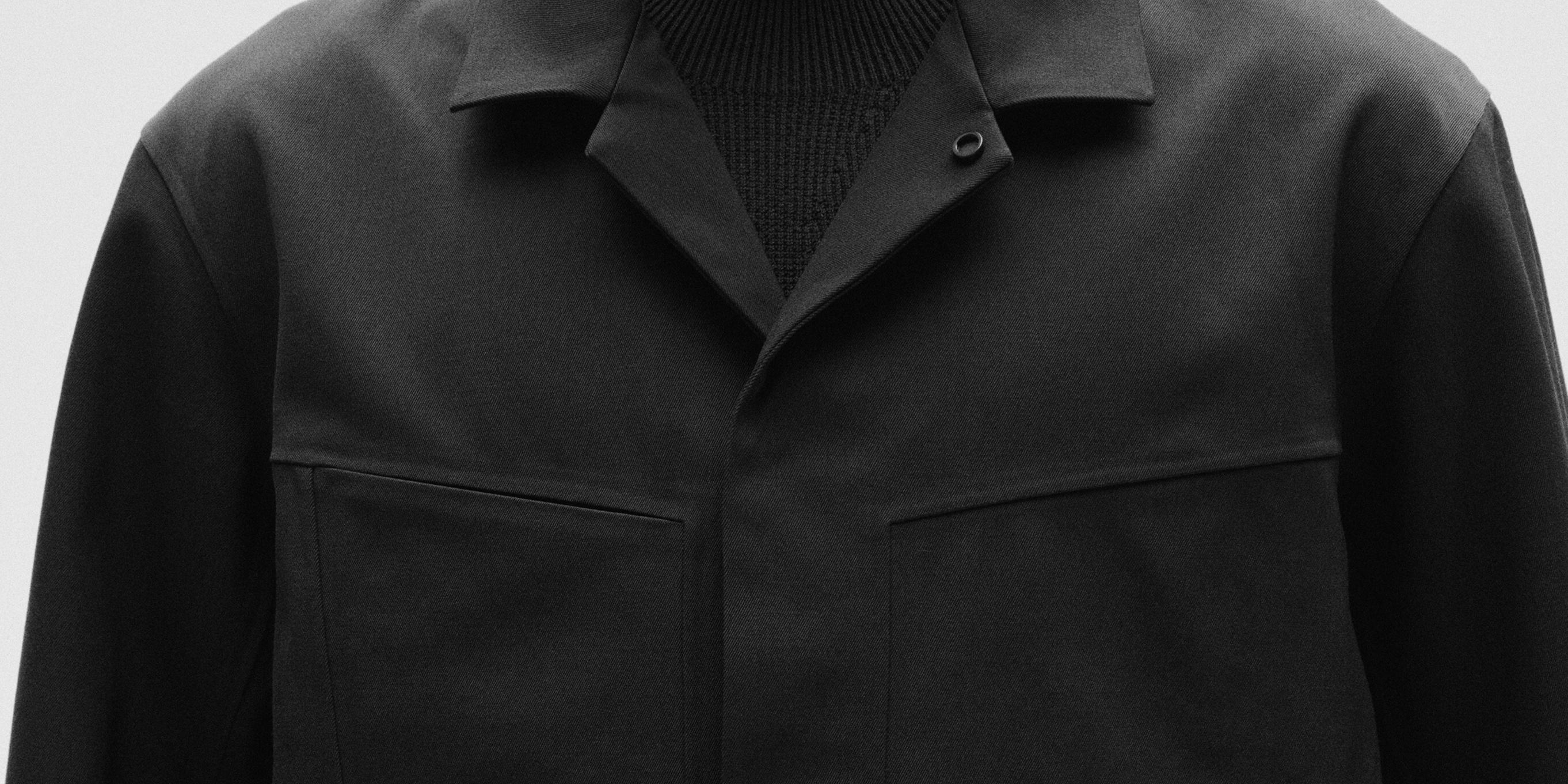 a close up of a person wearing a black jacket and a black turtleneck.