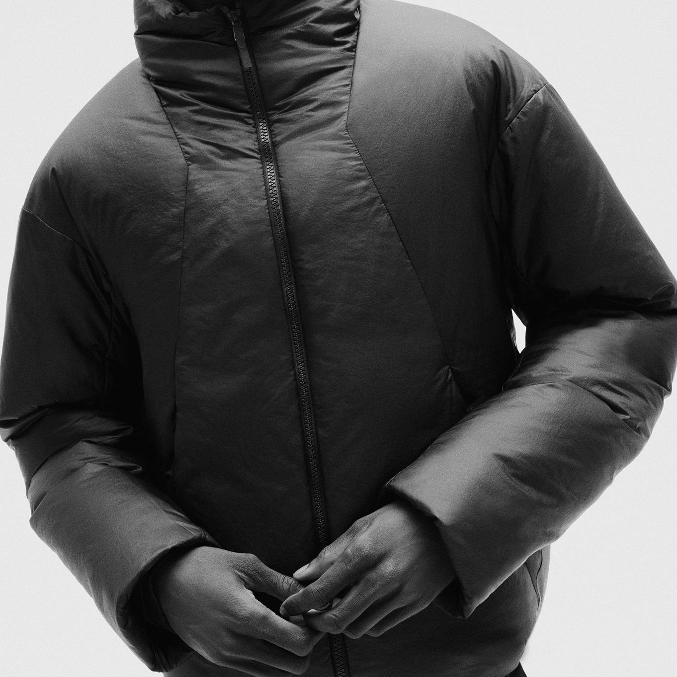 a black and white photo of a person wearing a black jacket.