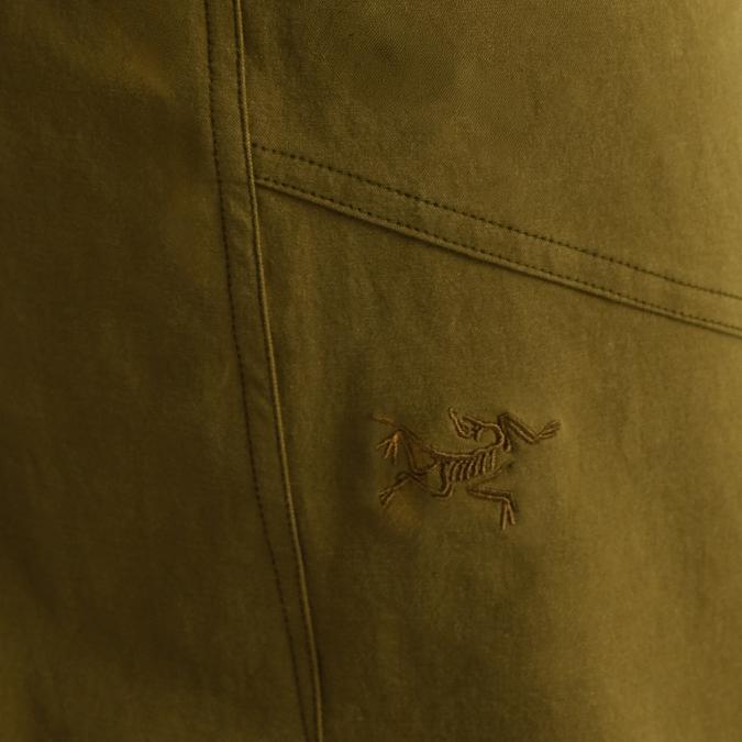 Close-up of olive green fabric with an embroidered Arc'teryx logo.