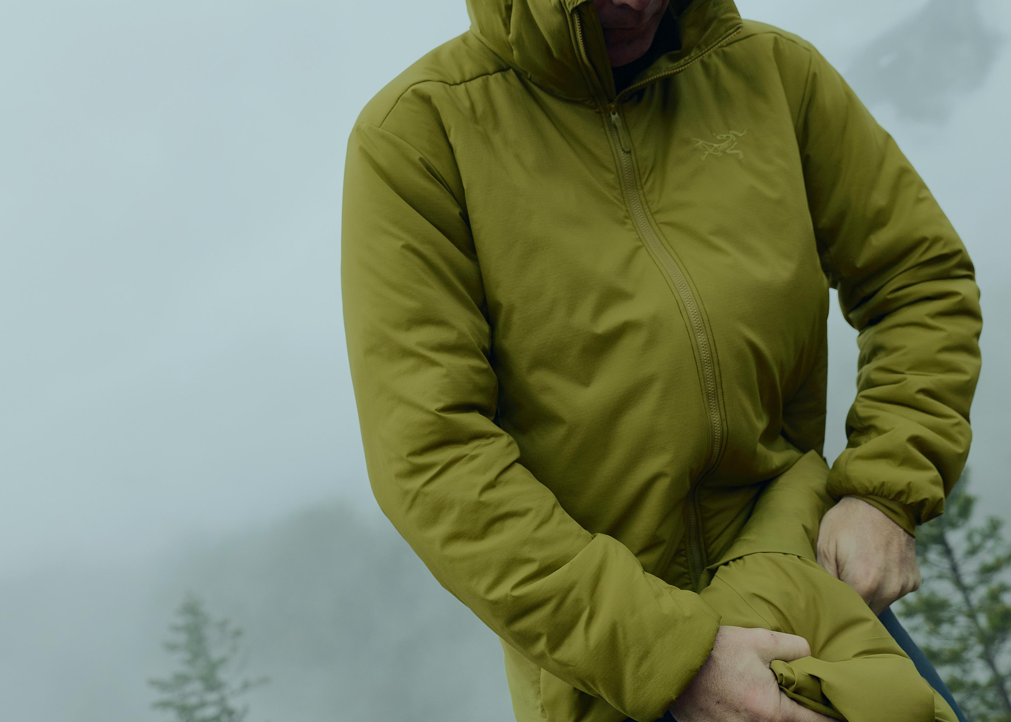 a person is wearing a green jacket with a hood .