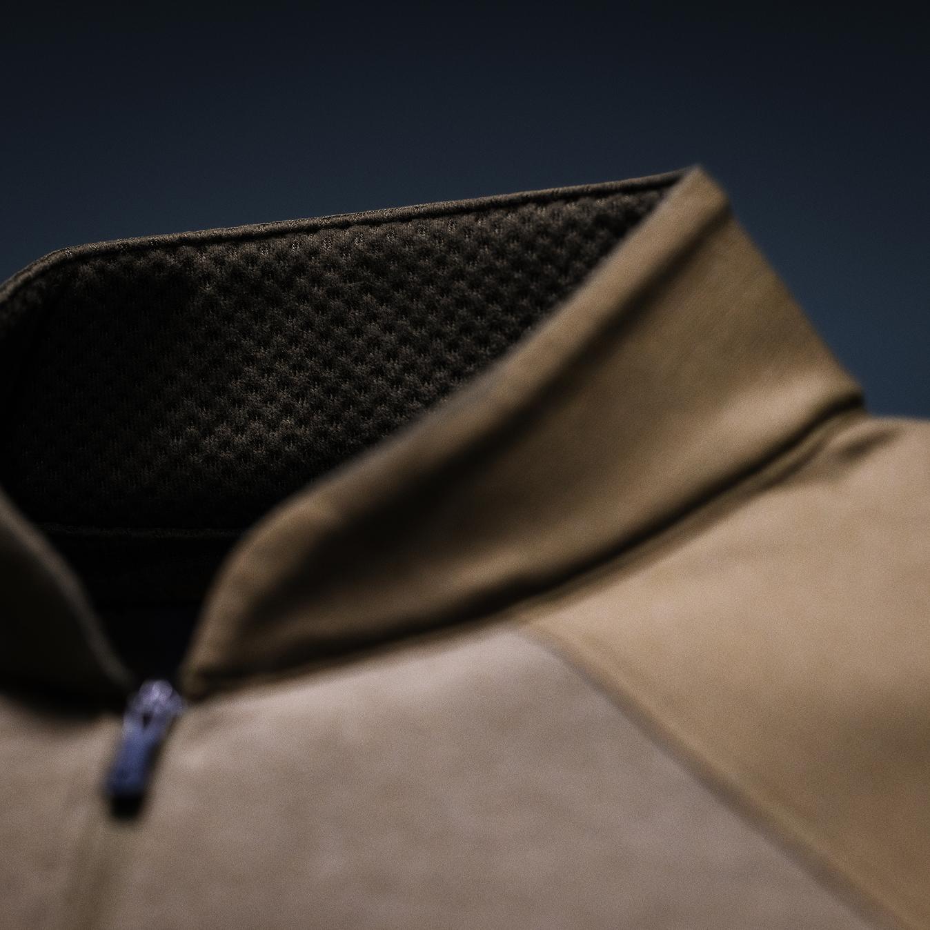 Tan shirt collar with dark mesh lining and blue zipper.