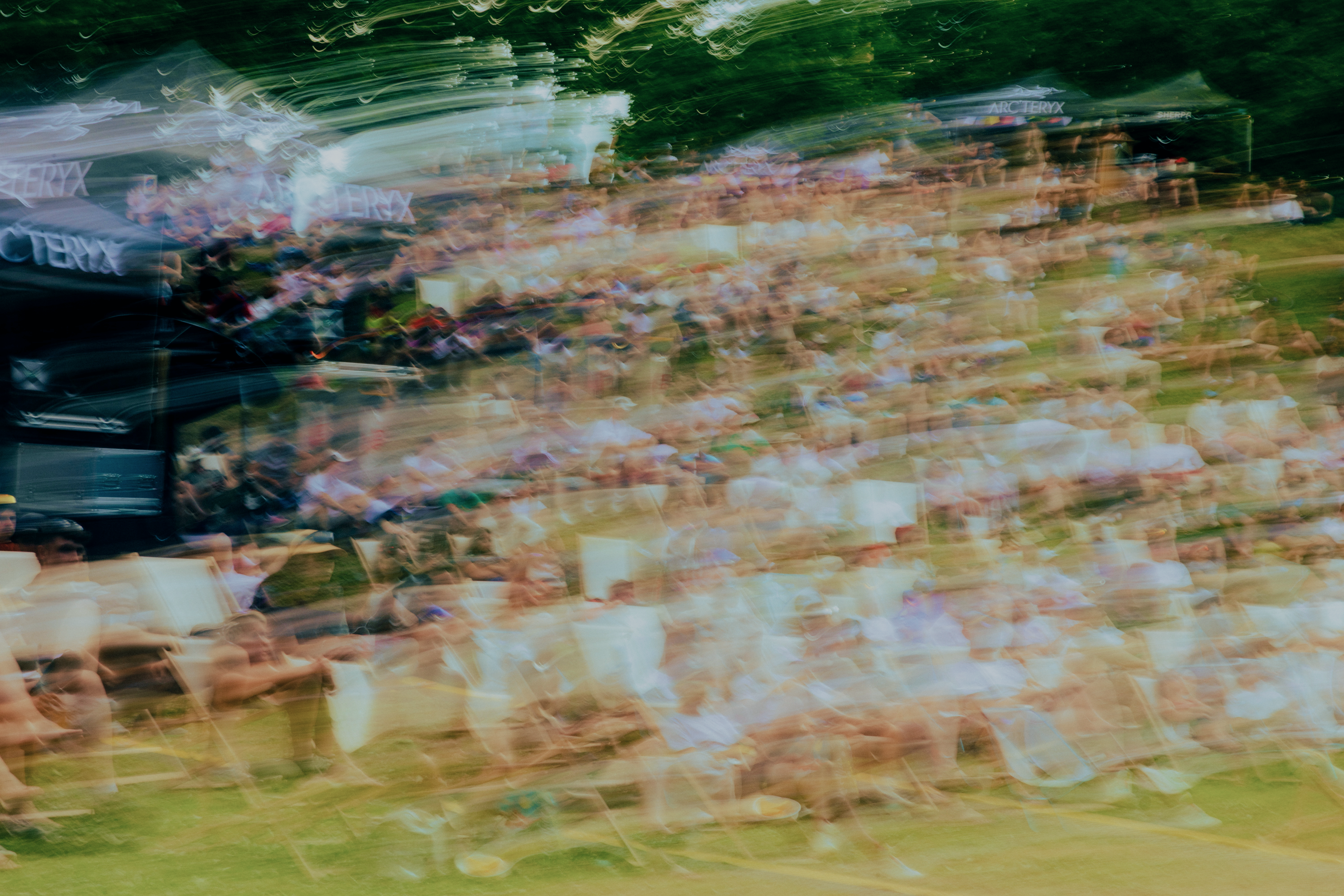 Heavily motion-blurred image of a large outdoor crowd with Arc'teryx branding.