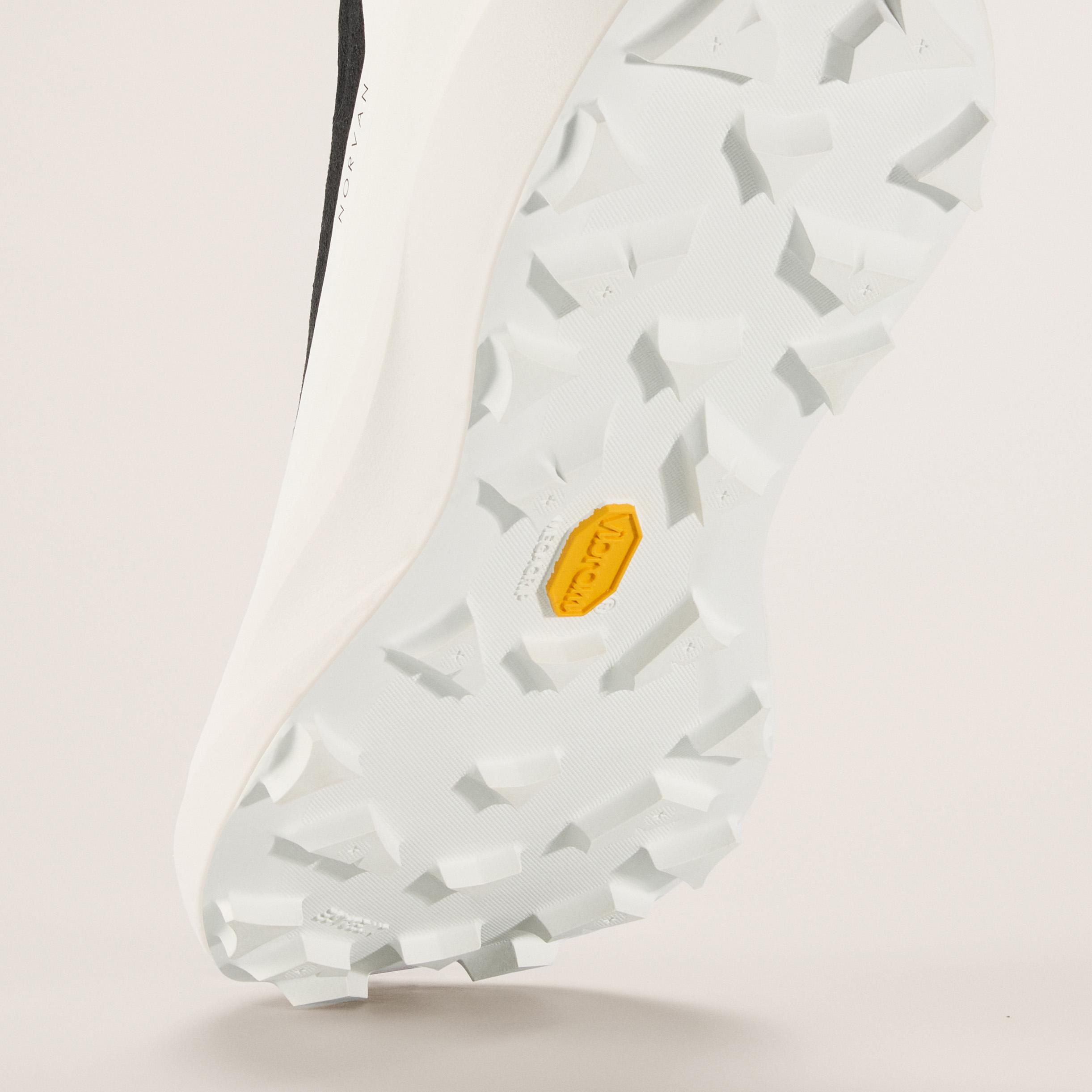 a close up of the bottom of a white shoe with a vibram rubber sole .