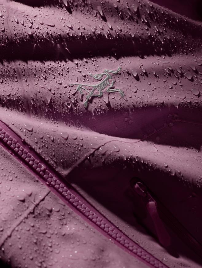 Pink Arc'teryx jacket with water droplets beading on the fabric.