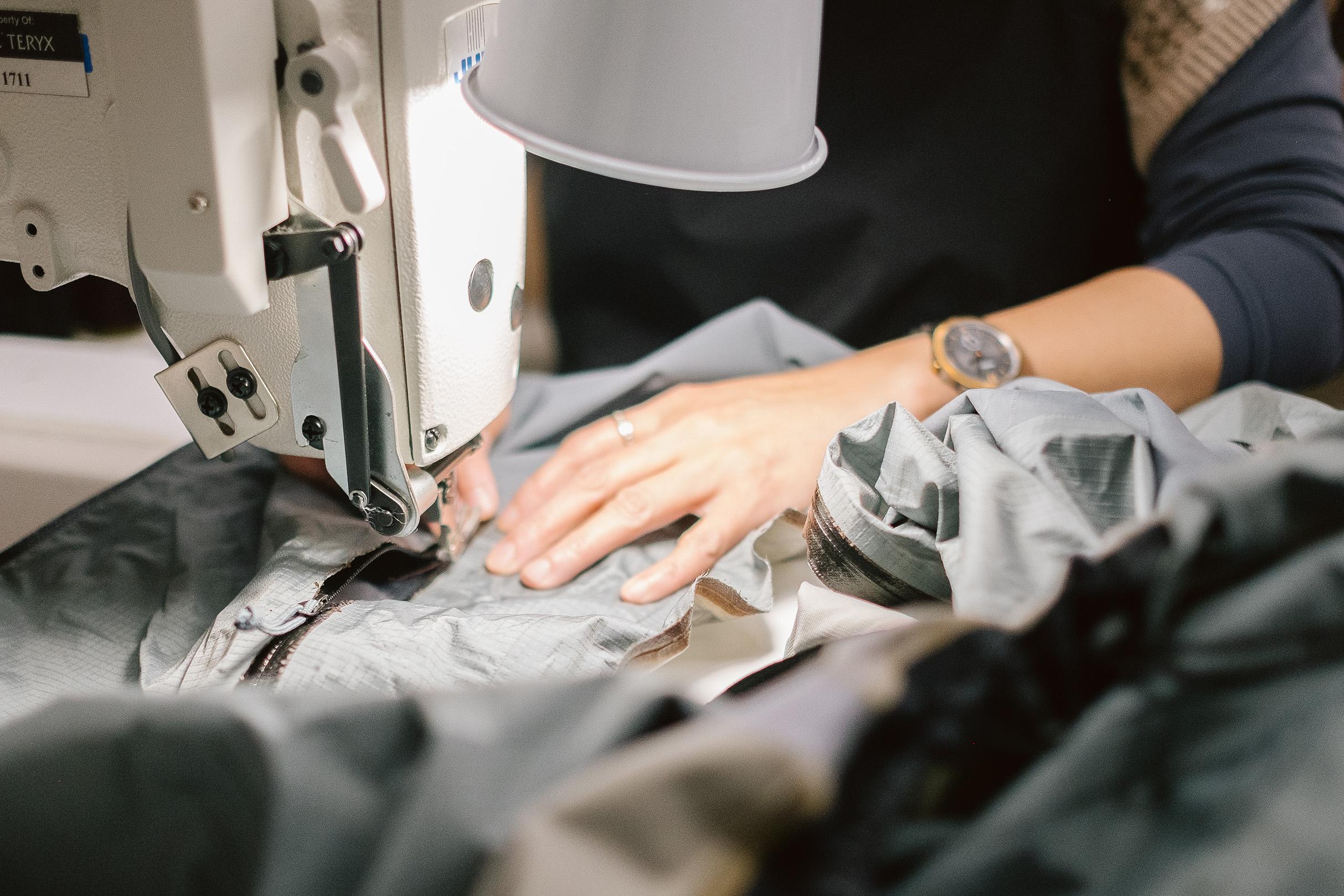 a person is using a sewing machine to sew a piece of fabric .