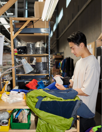 Manufacturing employee working on a jacket inside of the Arc'teryx warehouse.