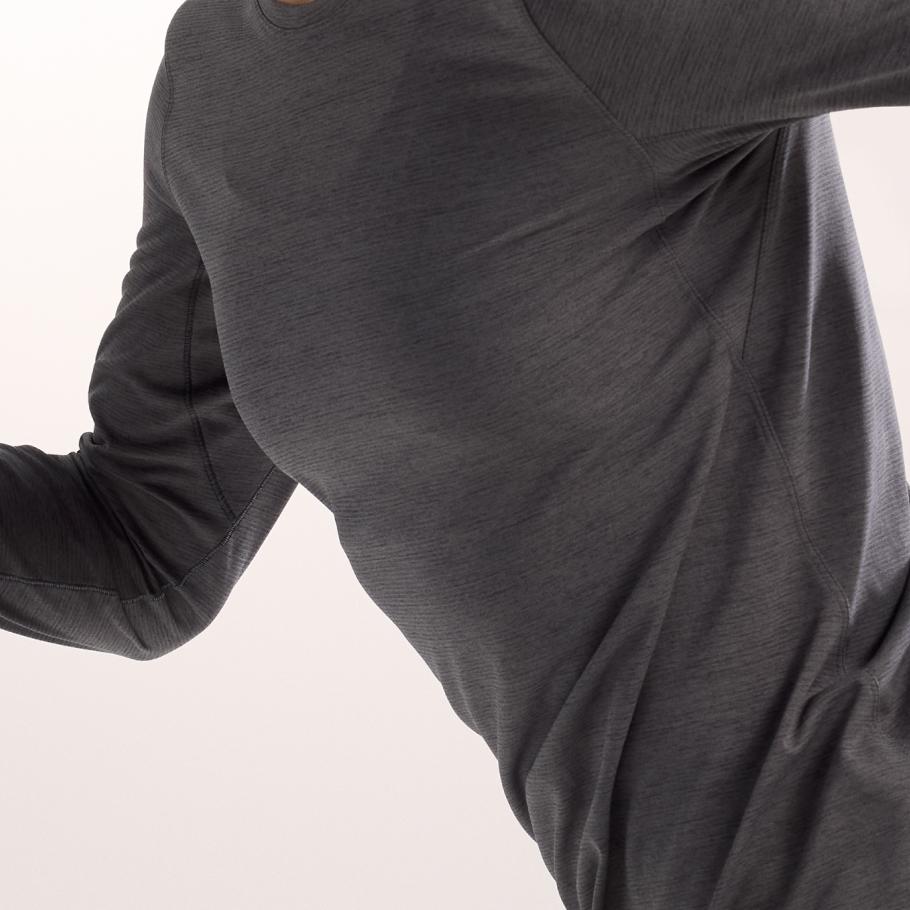 Upper body of a person wearing a dark gray textured long-sleeve shirt with visible stitching.