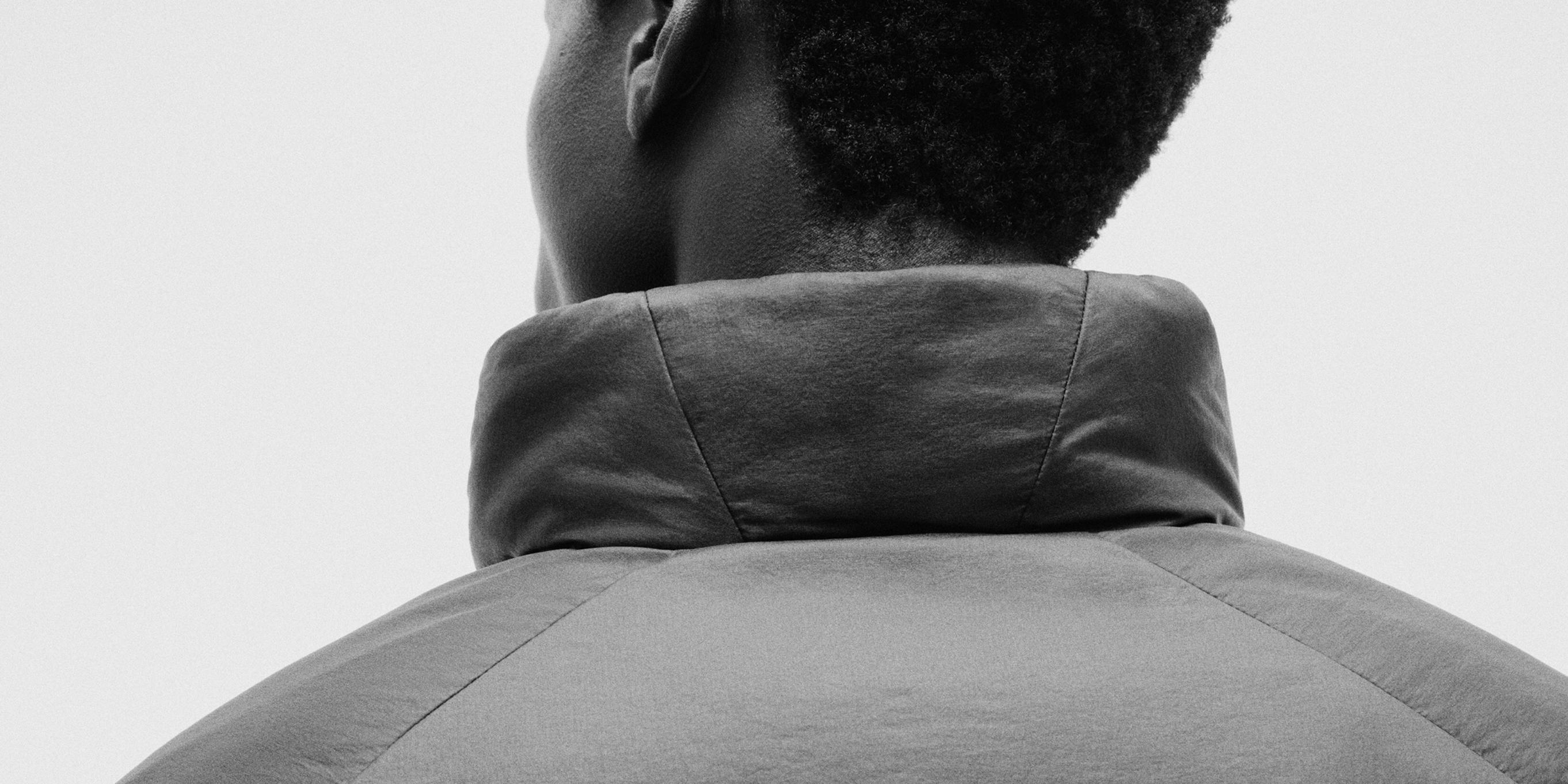 a black and white photo of a man wearing a jacket .