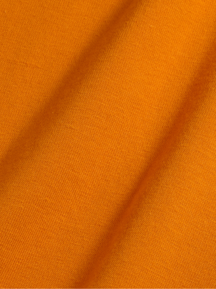 Orange fabric with a visible texture and diagonal folds.