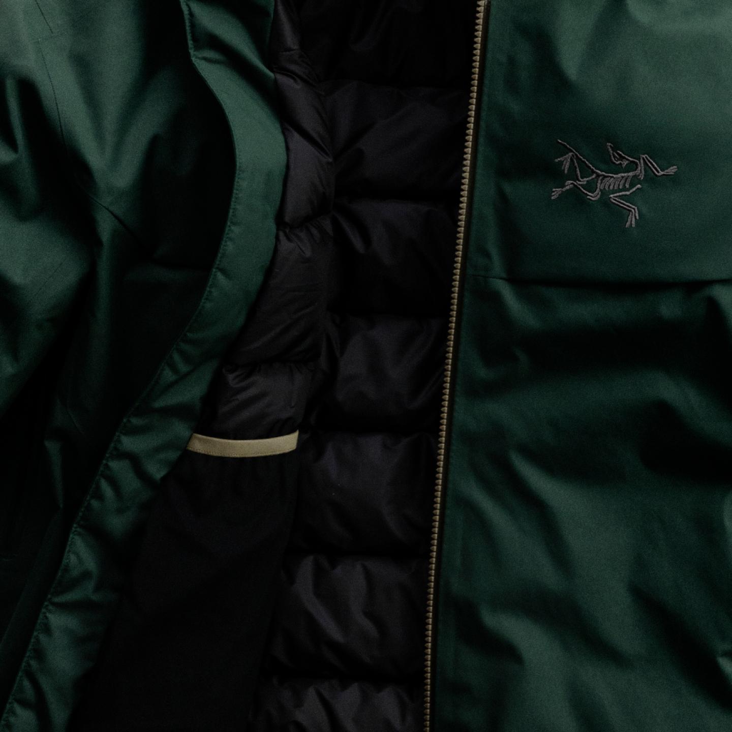 Dark green jacket with Arc'teryx logo, partially open revealing a black puffer lining.