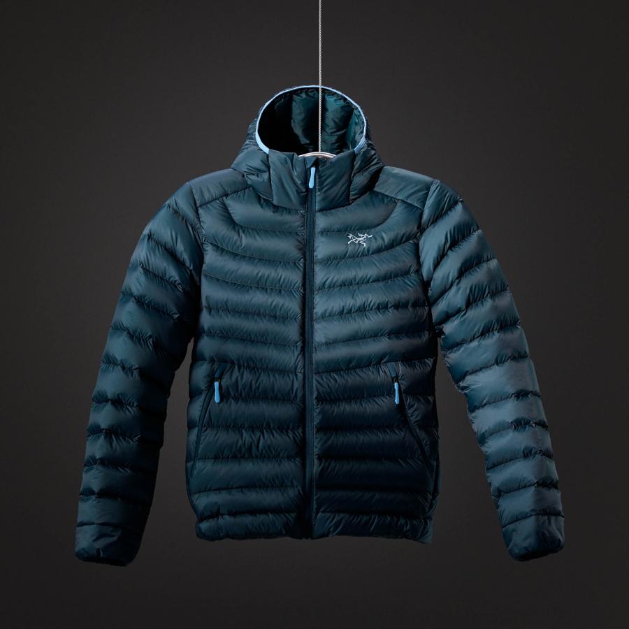 a blue down jacket with a hood is hanging on a hanger .