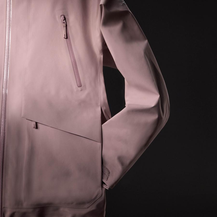 a close up of a person wearing a pink jacket on a black background .