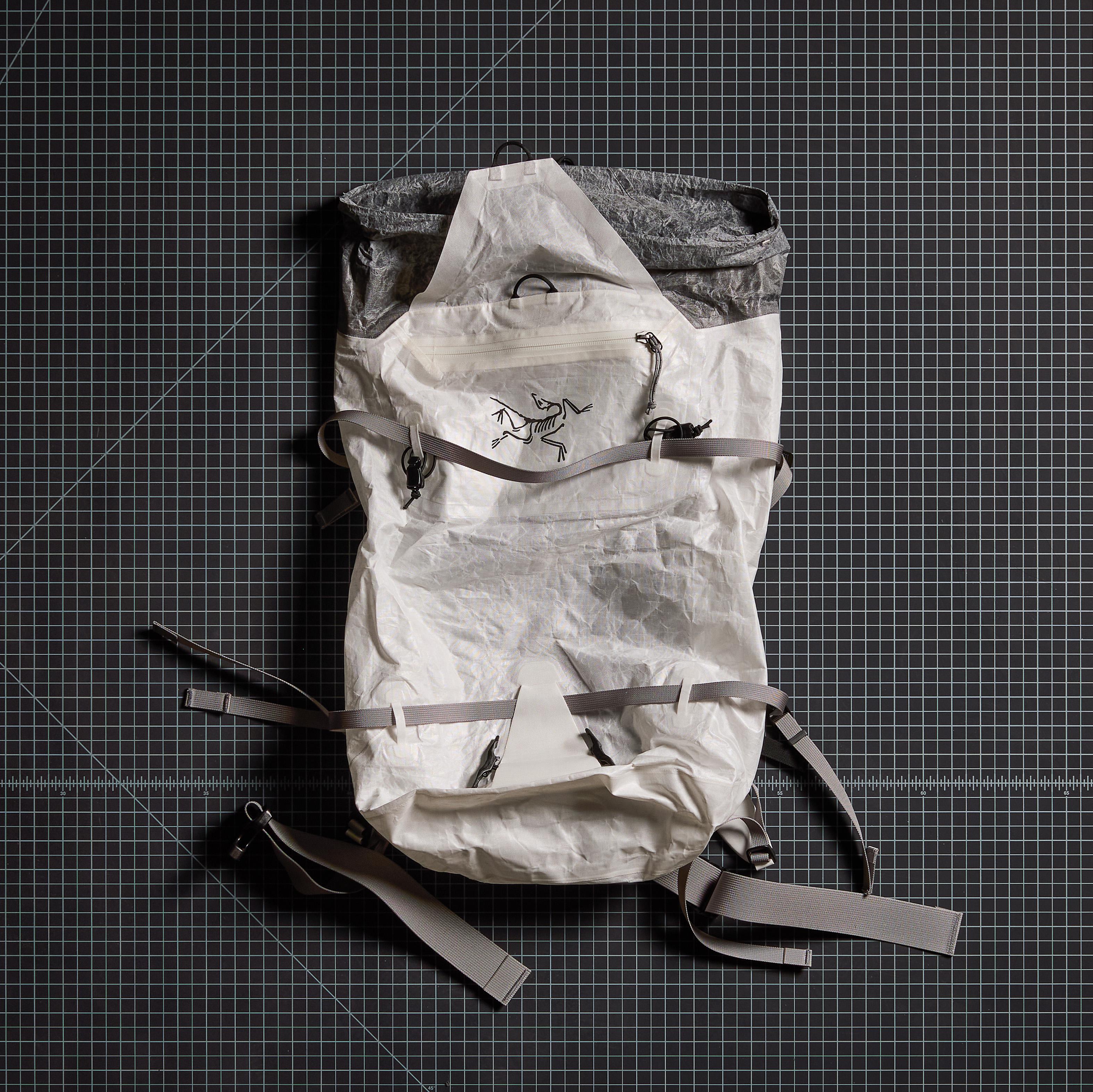 a white backpack is sitting on top of a black cutting mat