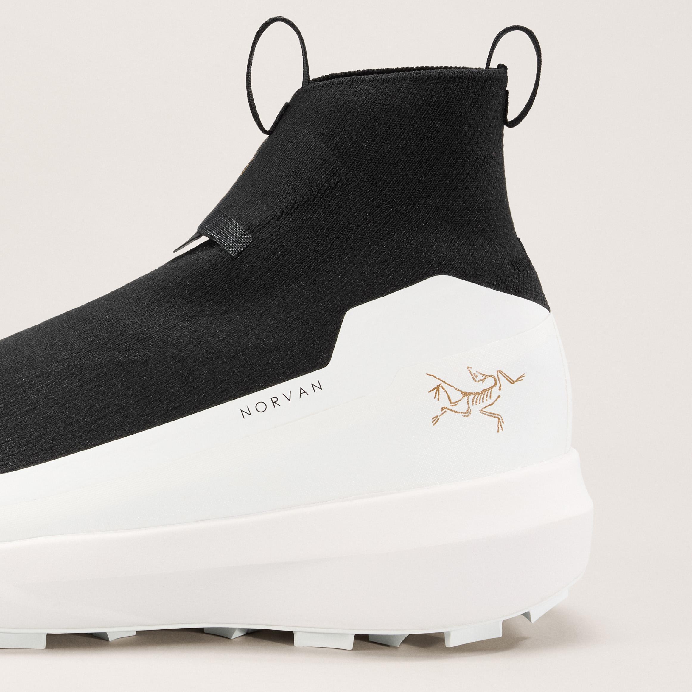 a close up of a pair of black and white shoes with a logo on the side .