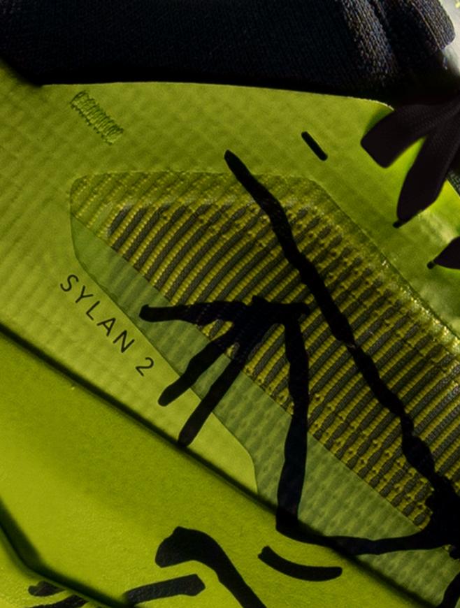 Close-up of a lime green running shoe with translucent mesh and "SYLAN 2" text.