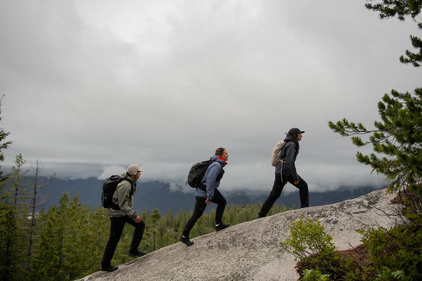 a group of people are hiking up a mountain wearing waterproof GORE-TEX rain jackets