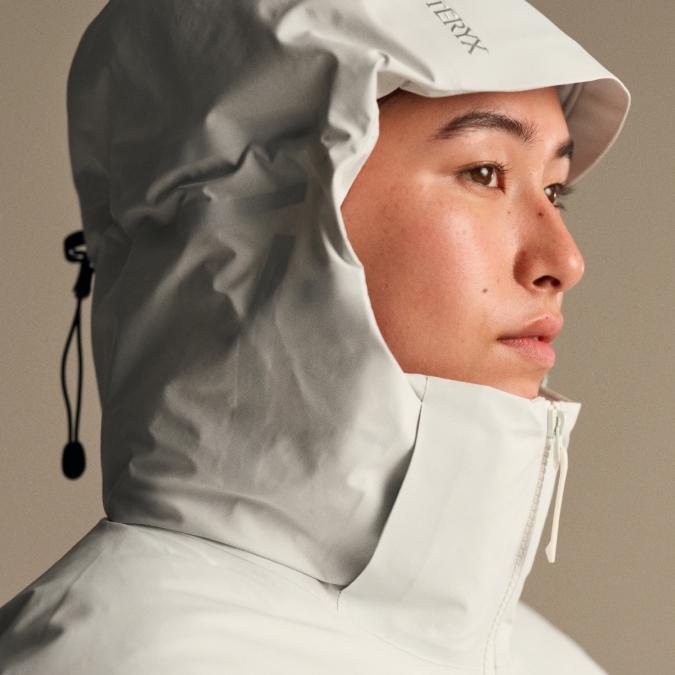 Profile of a person wearing a light grey Arc'teryx hooded jacket.