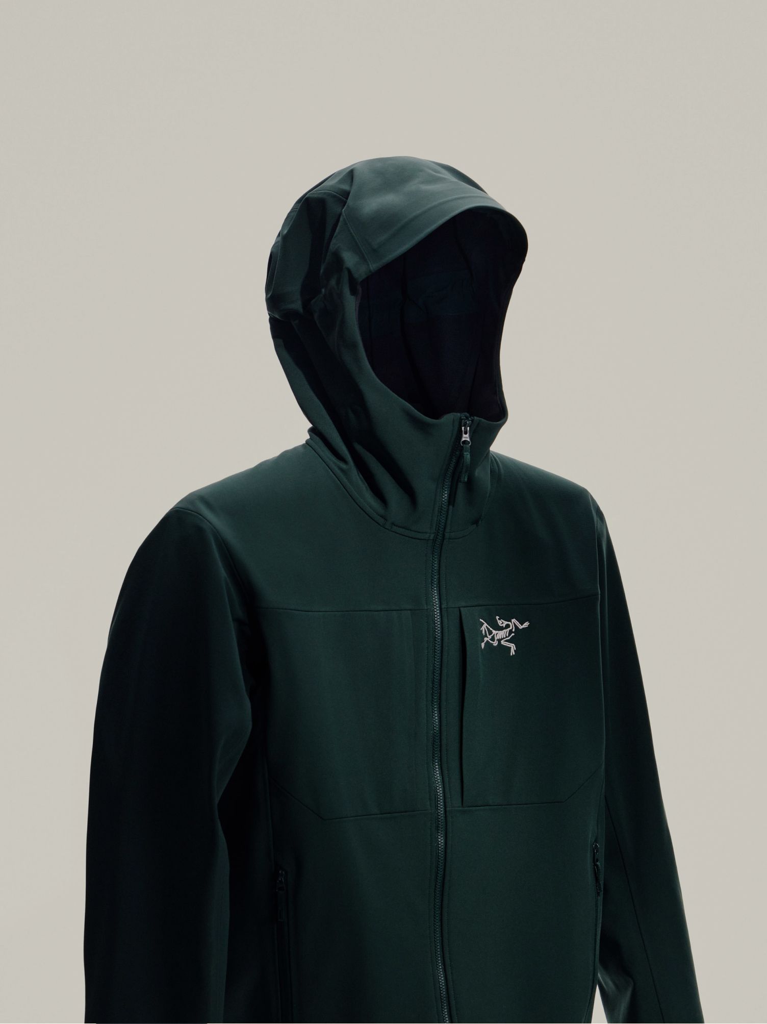 Black Arc'teryx technical jacket next to a close-up of its dark, patterned fabric.