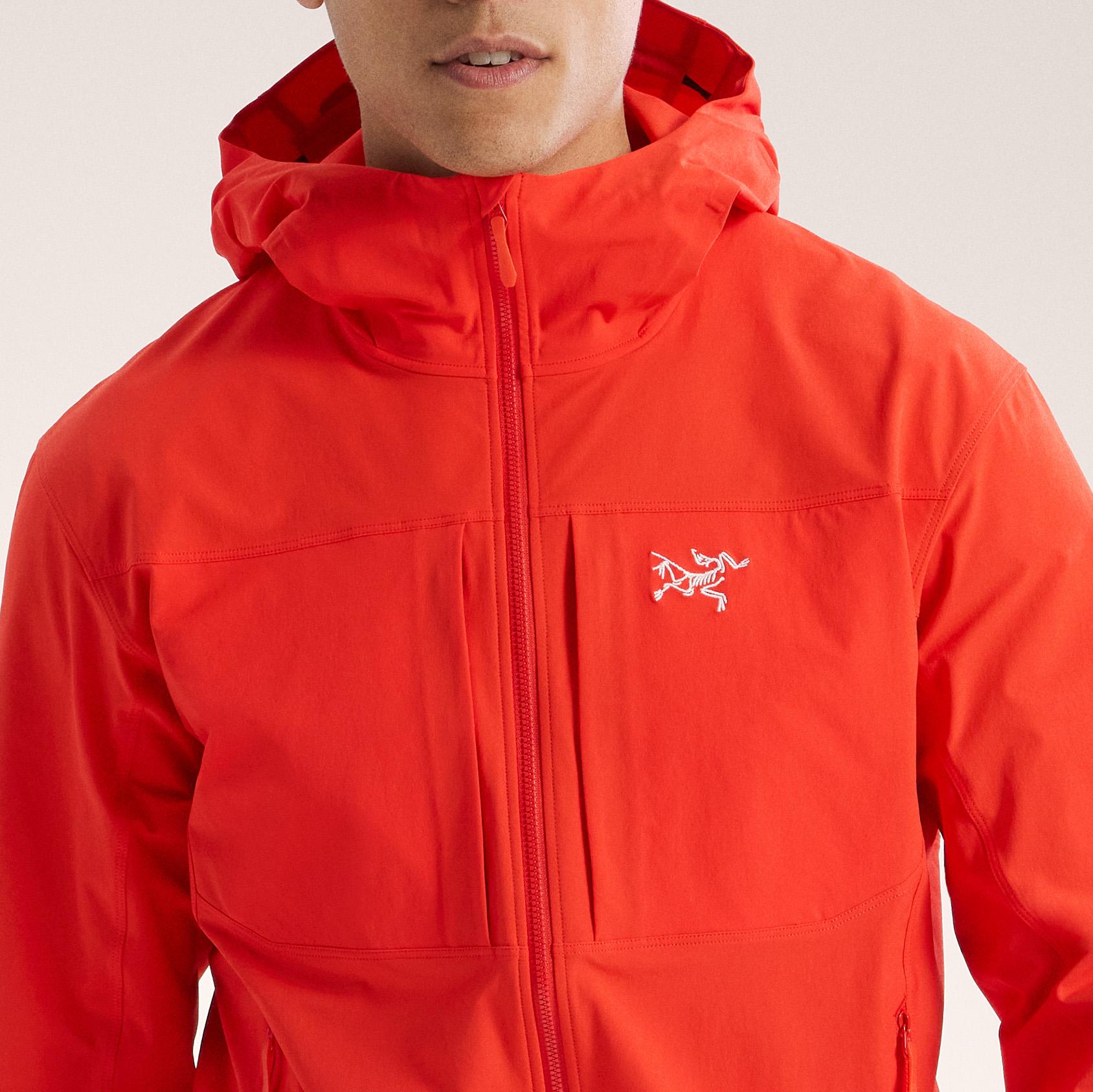 a man is wearing a red jacket with a hood .