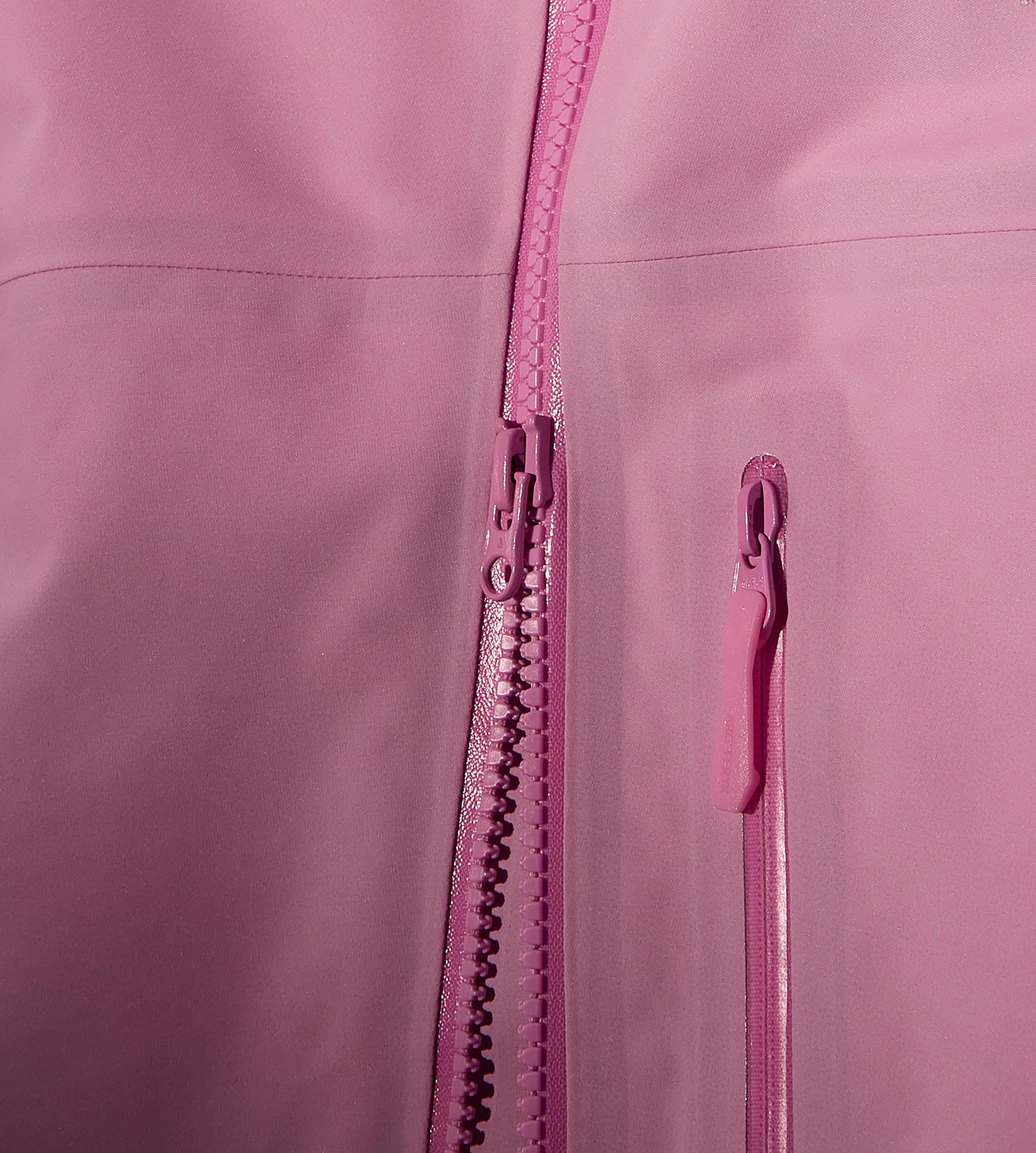 Close-up of a pink jacket showing a partially unzipped front zipper and a smaller pocket zipper, both pink.