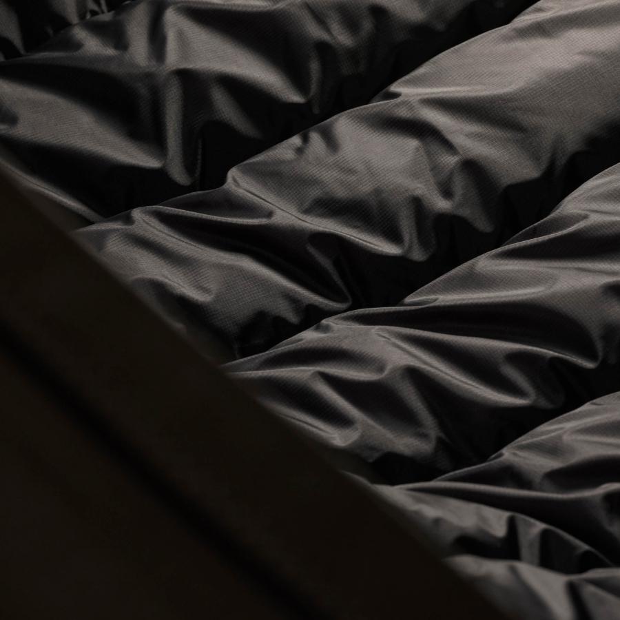 a close up of a black blanket on a bed .