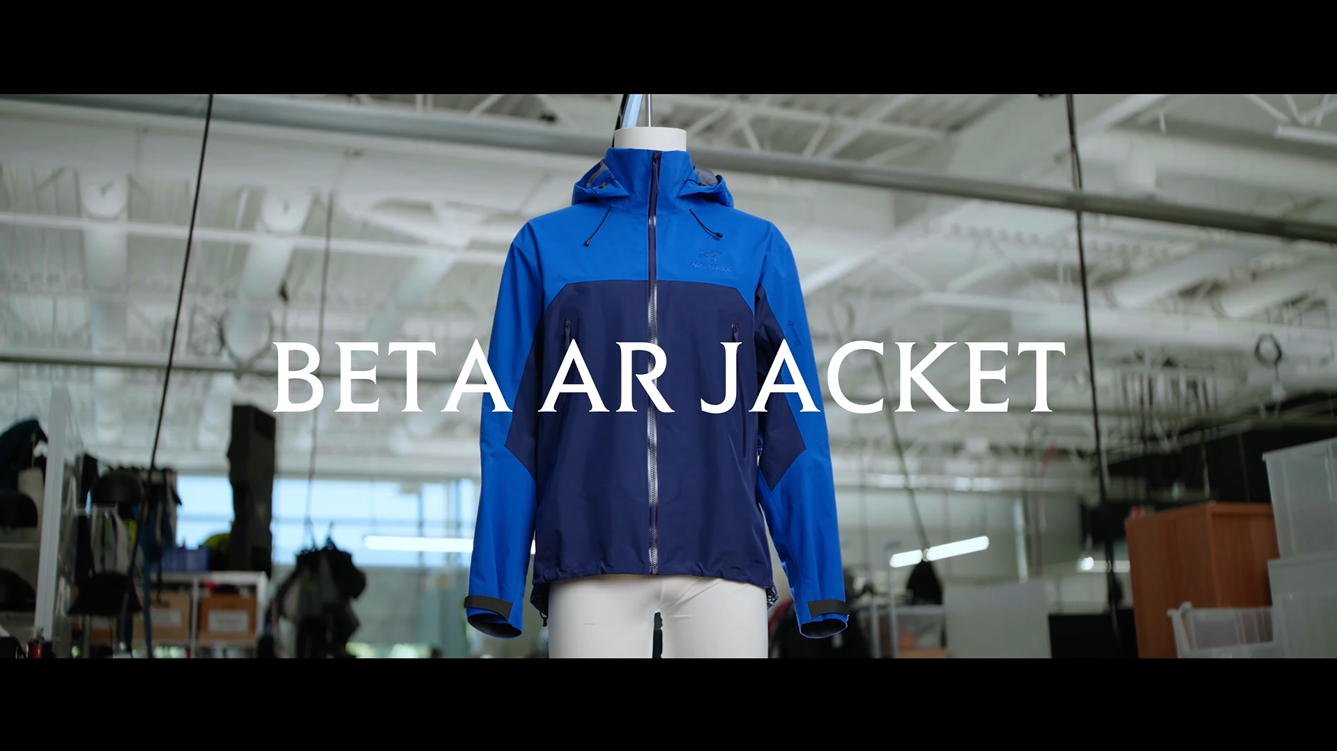 Blue and navy Beta AR jacket on a mannequin with the text "BETA AR JACKET".