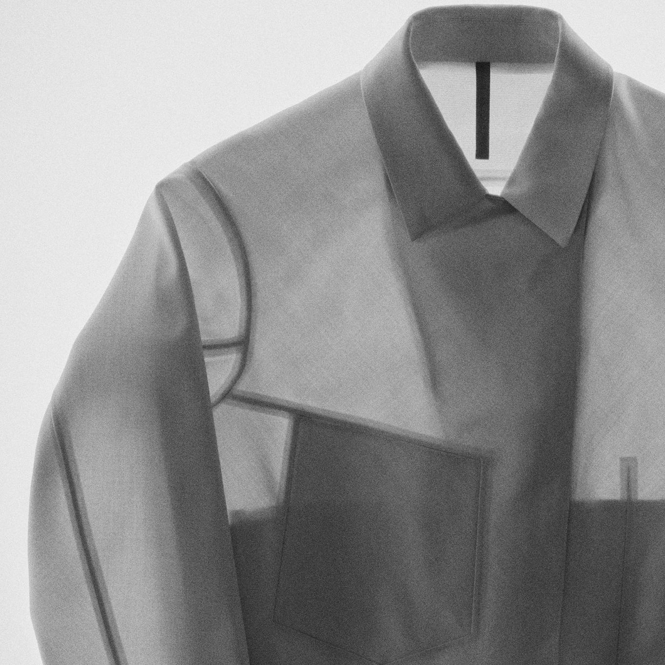 a gray shirt with a black collar is hanging on a hanger