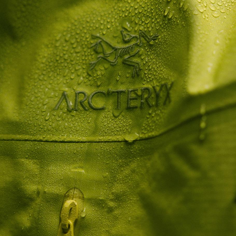 Close-up of a lime green Arc'teryx jacket covered in water droplets.