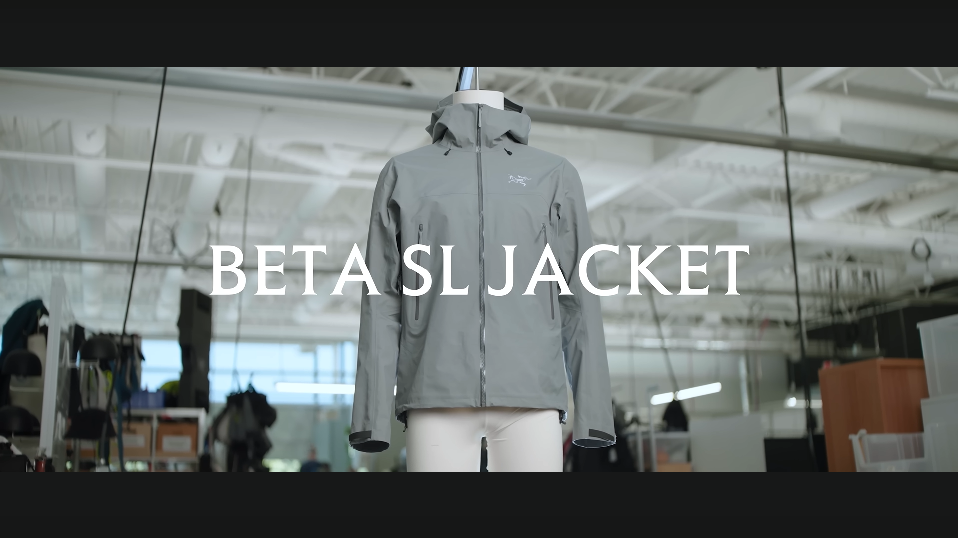 A light grey hooded Arc'teryx Beta SL jacket on a mannequin, with the text "BETA SL JACKET" superimposed.