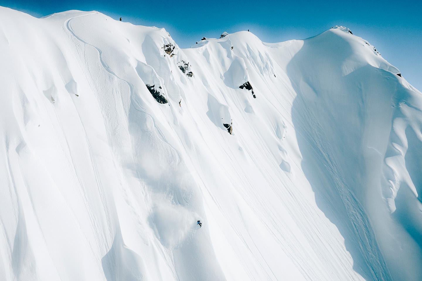 an aerial view of a person skiing down a snow covered mountain