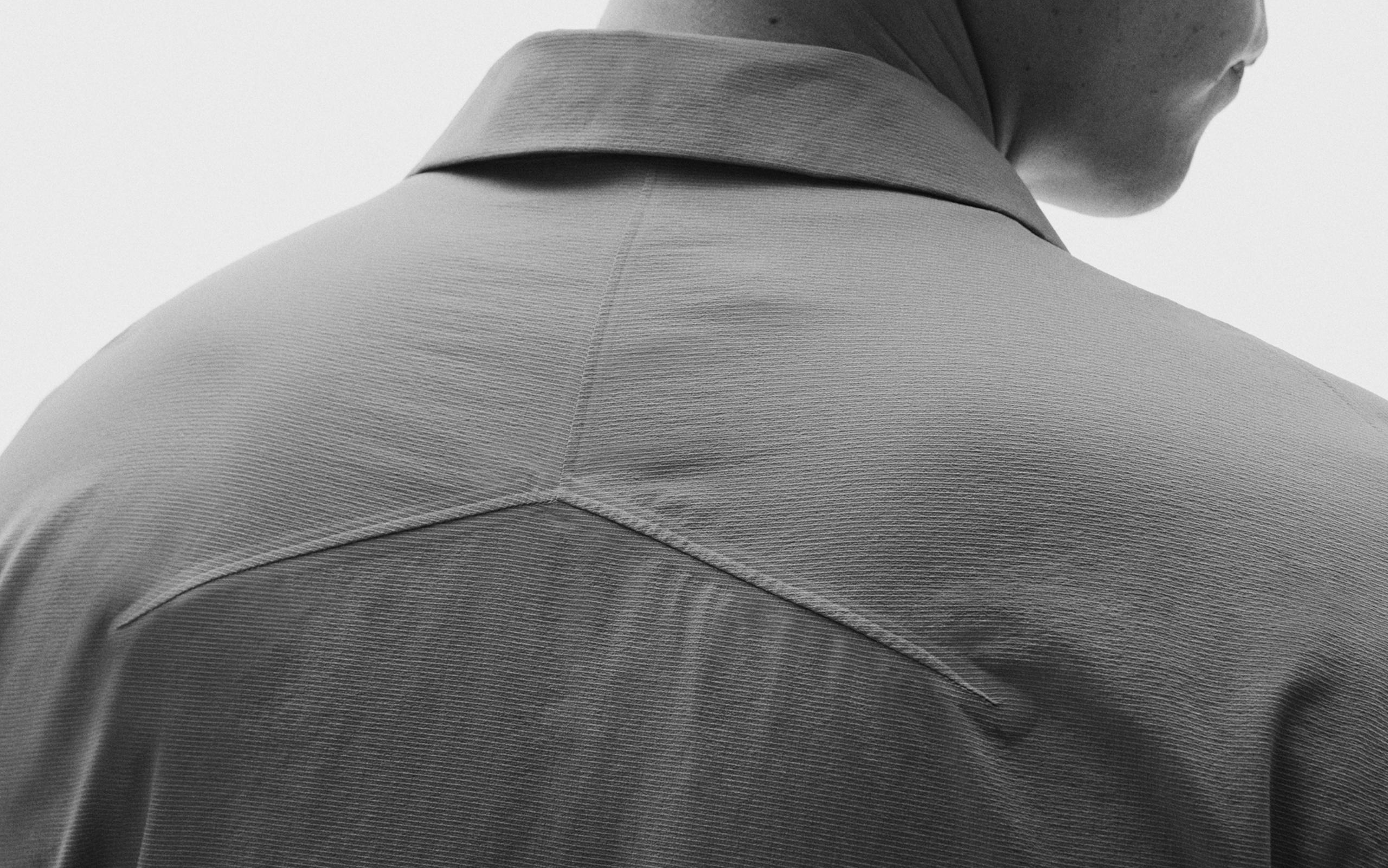 Close-up of the back of a shirt on a person, showing a textured fabric and a distinctive stitched yoke.