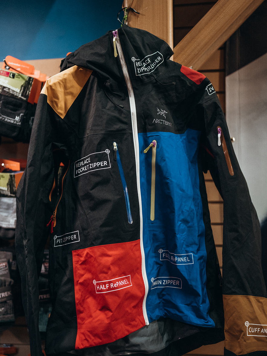 A multi-colored Arc'teryx jacket marked with labels for different repair services.