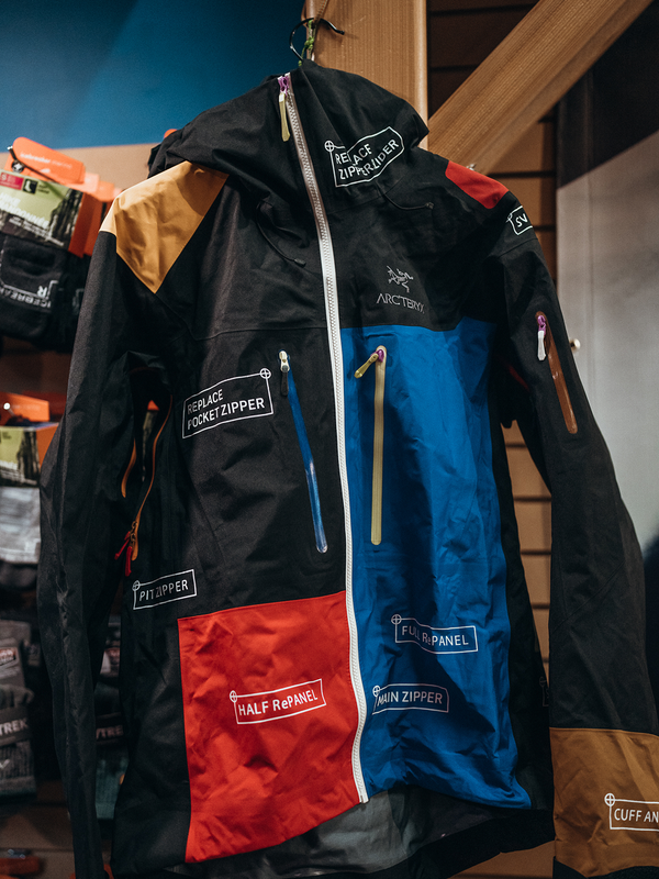 A multi-colored Arc'teryx jacket marked with labels for different repair services.
