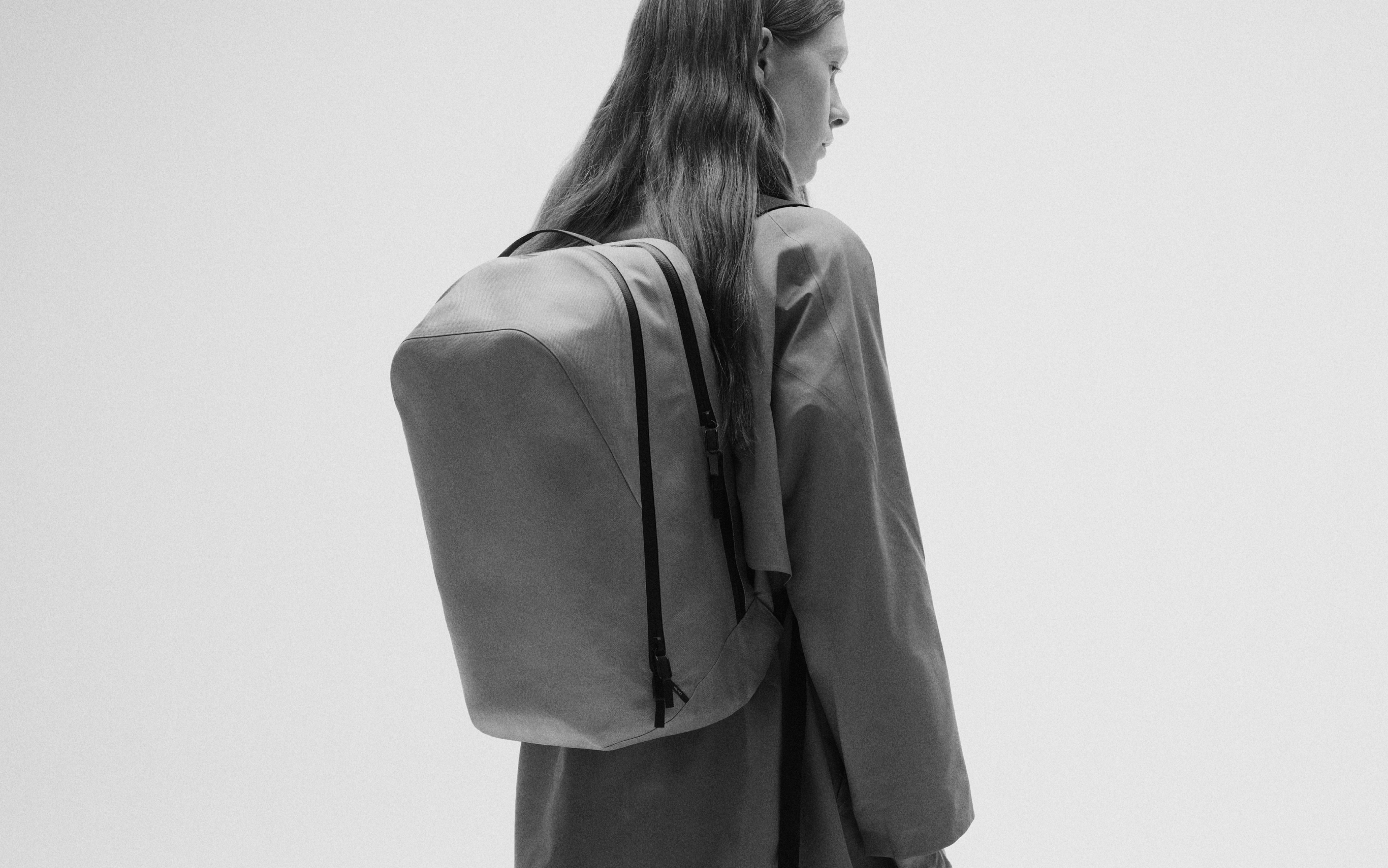 A person seen from behind wearing a backpack.