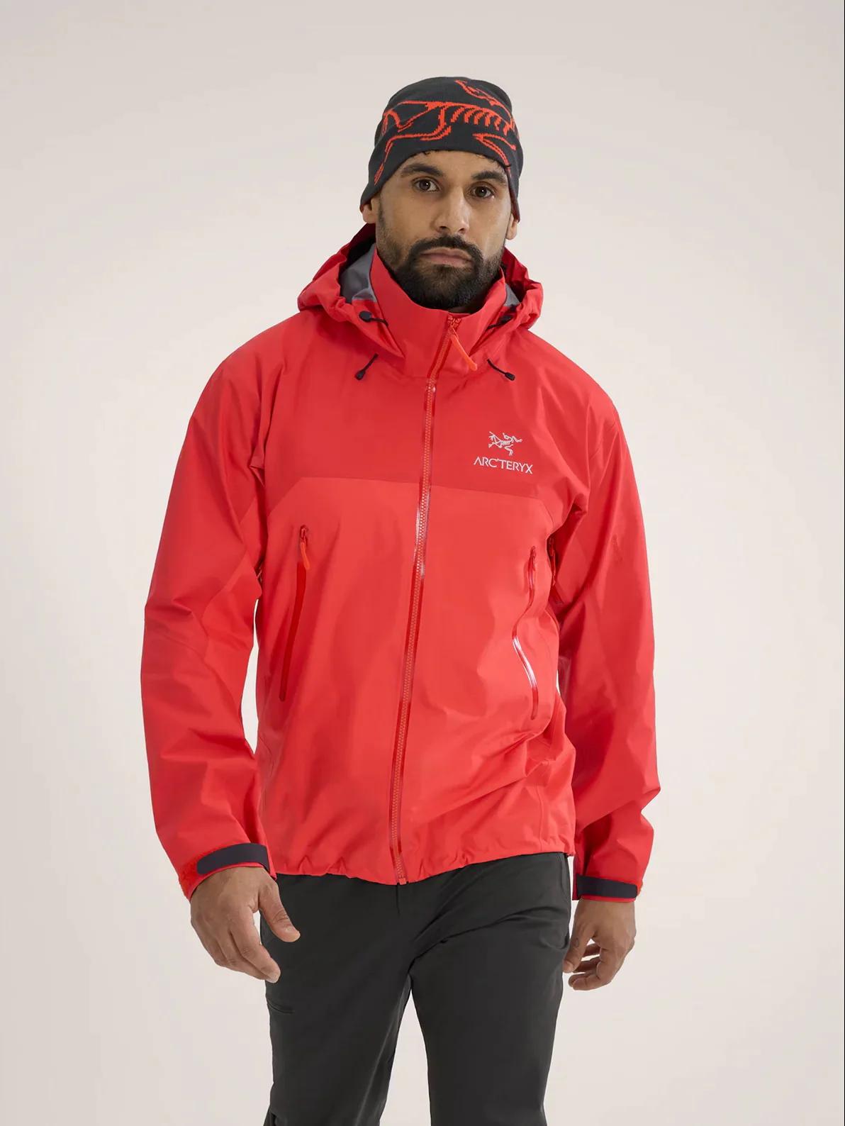 Man in red Arc'teryx jacket, black beanie, and dark pants.