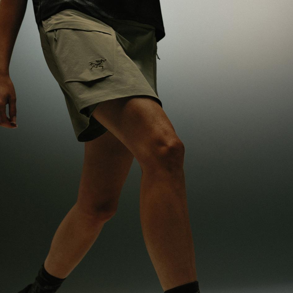 A person walks wearing olive green Arc'teryx cargo shorts.