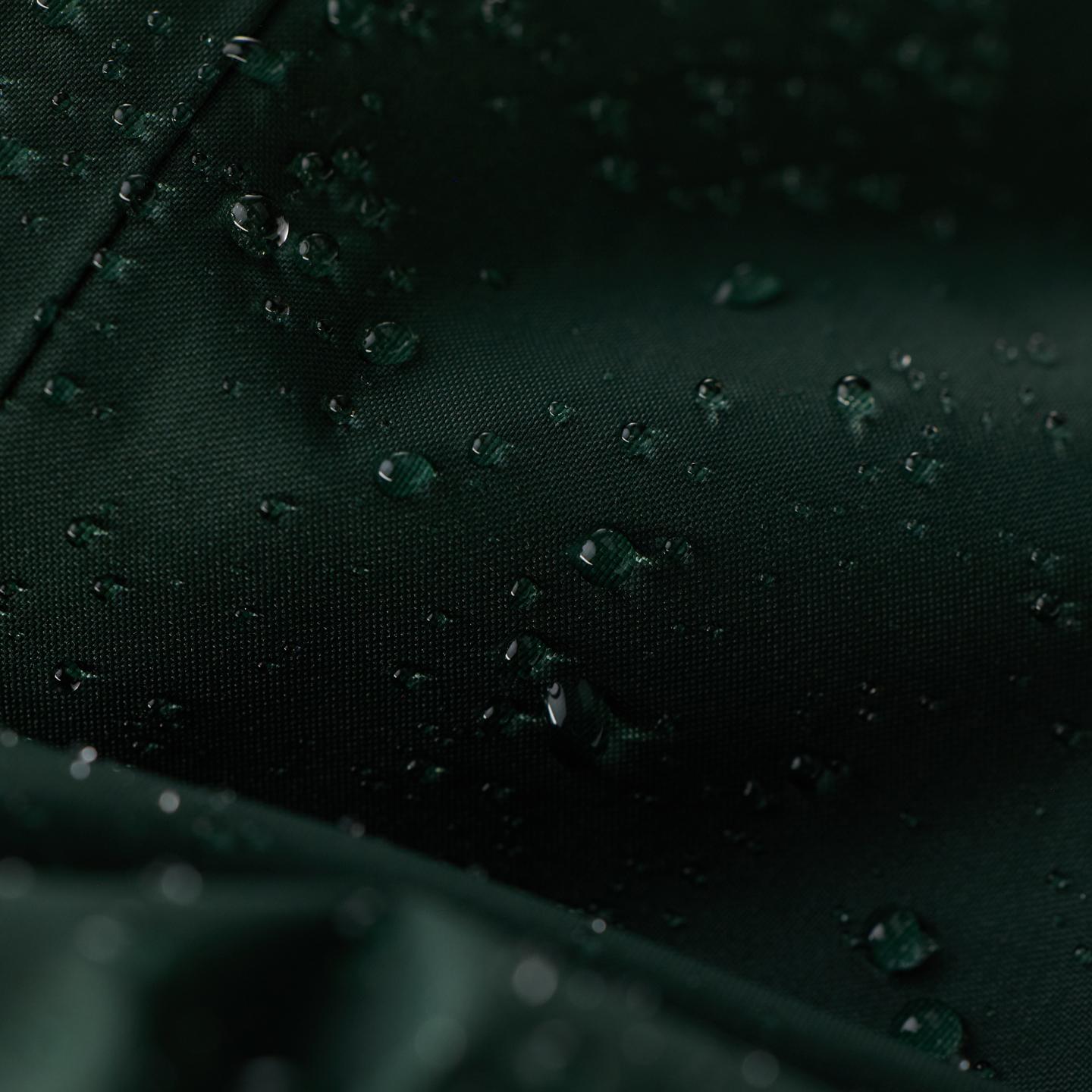 Water droplets beading on dark green waterproof fabric.
