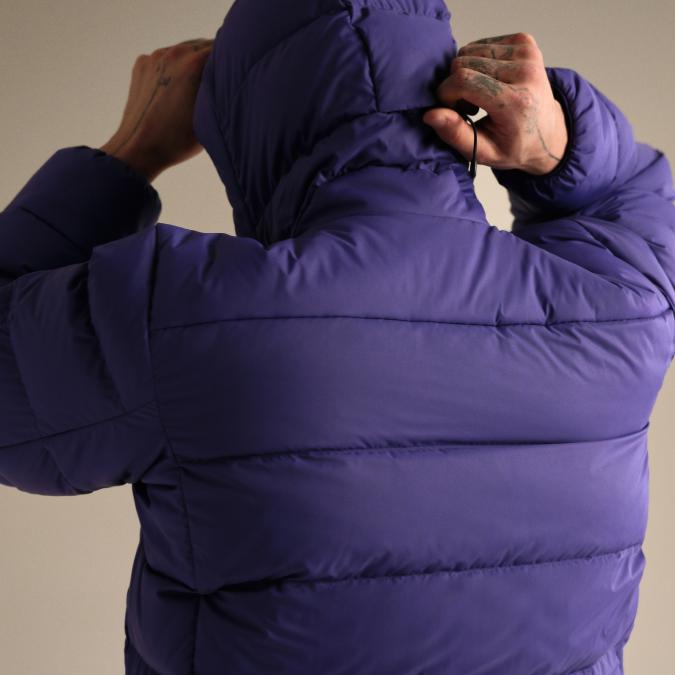 Back of person in purple puffer jacket, adjusting the hood.