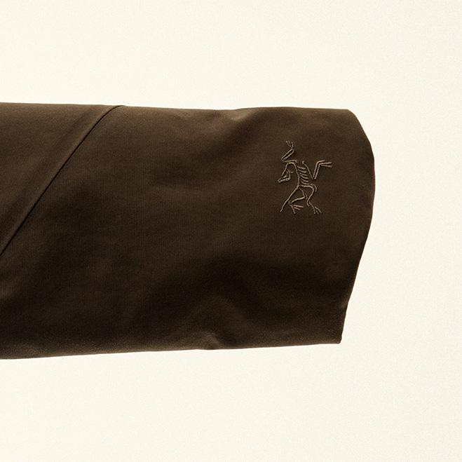 Close-up of a dark brown sleeve with an embroidered Arc'teryx logo.