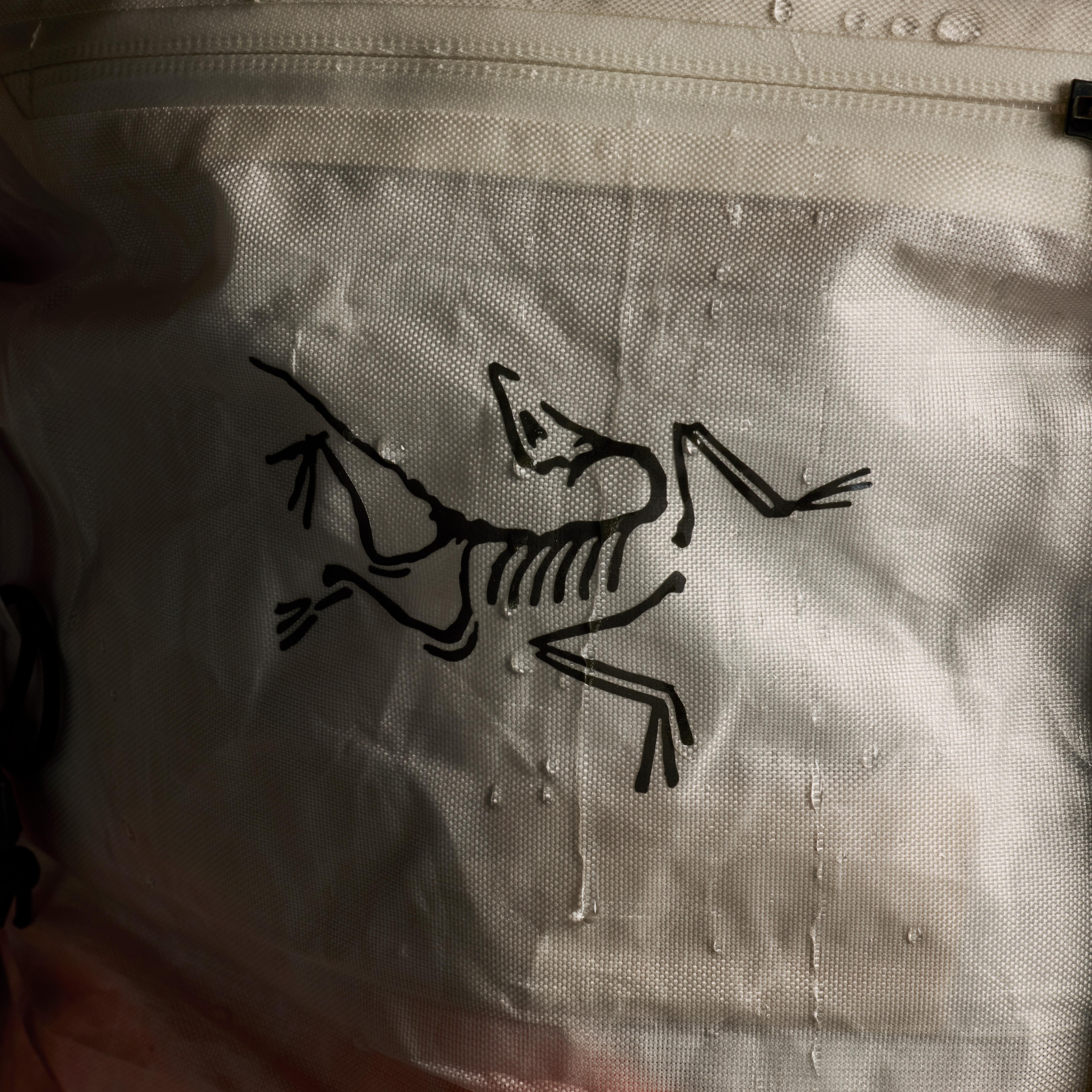 a white bag with a black Arc'teryx bird logo on it