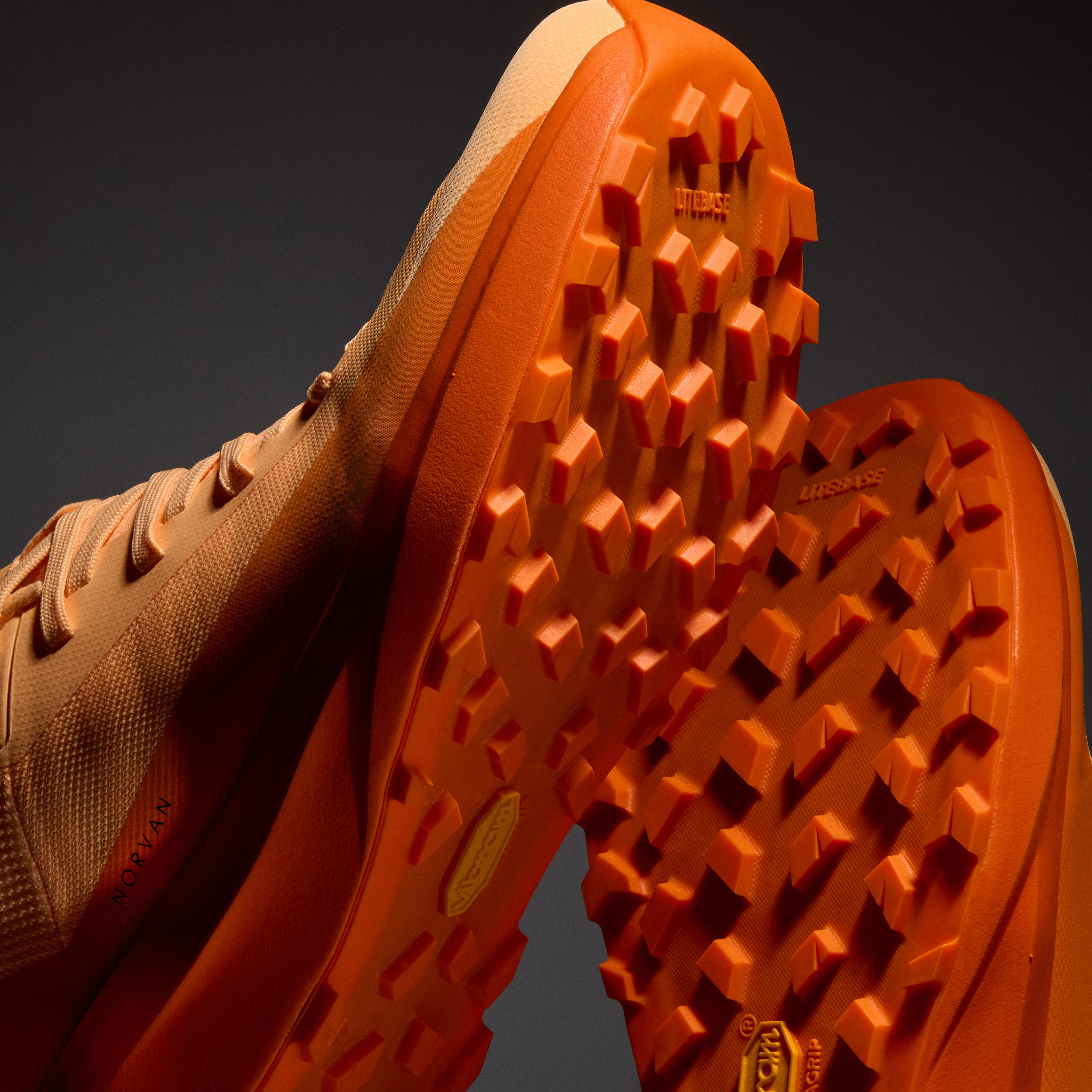 a pair of orange shoes with a vibram rubber sole