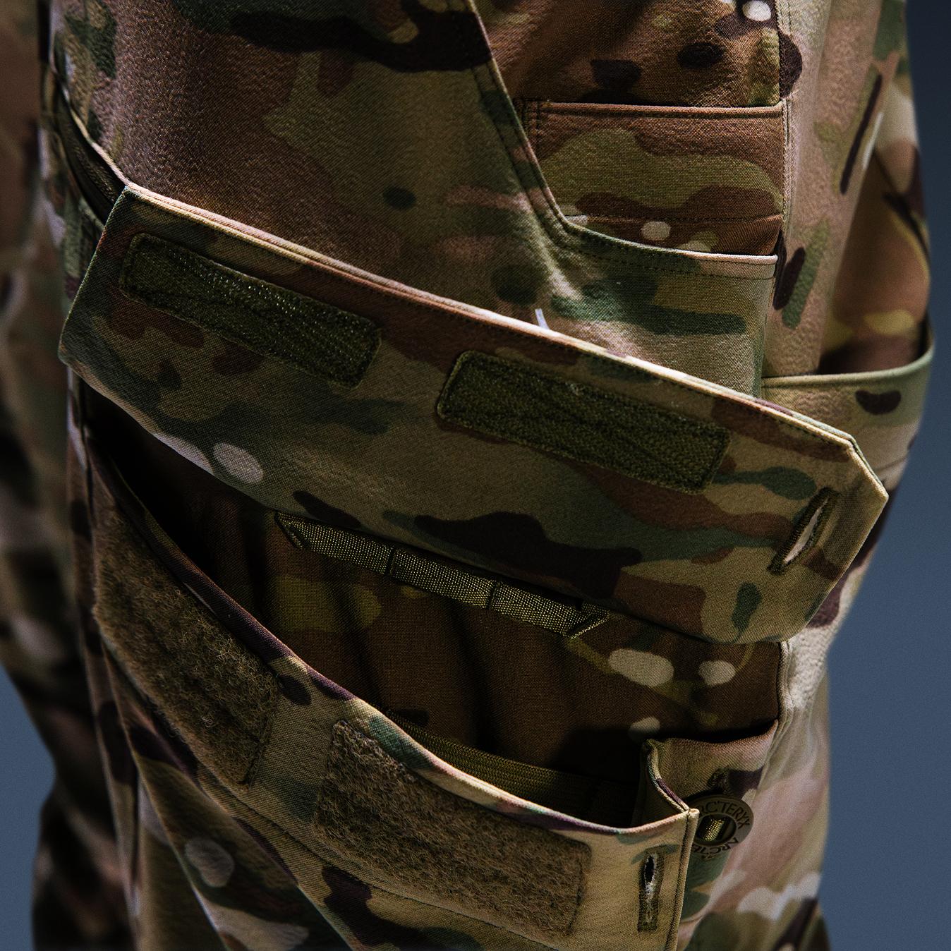 Close-up of Multicam camouflage tactical pants with Velcro-closure pockets.