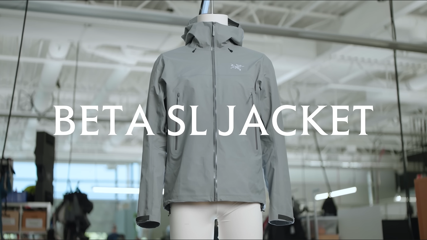 A light grey hooded Arc'teryx Beta SL jacket on a mannequin, with the text "BETA SL JACKET" superimposed.