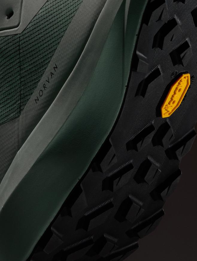 Close-up of a dark green Norvan shoe with a black Vibram sole.
