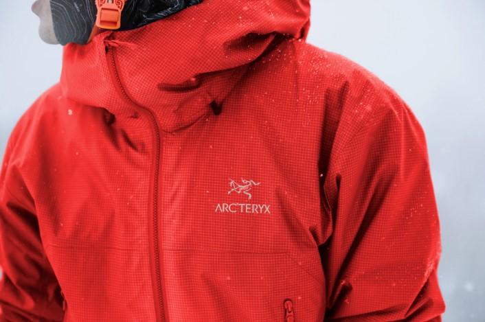 Red Arc'teryx jacket lightly dusted with snow.