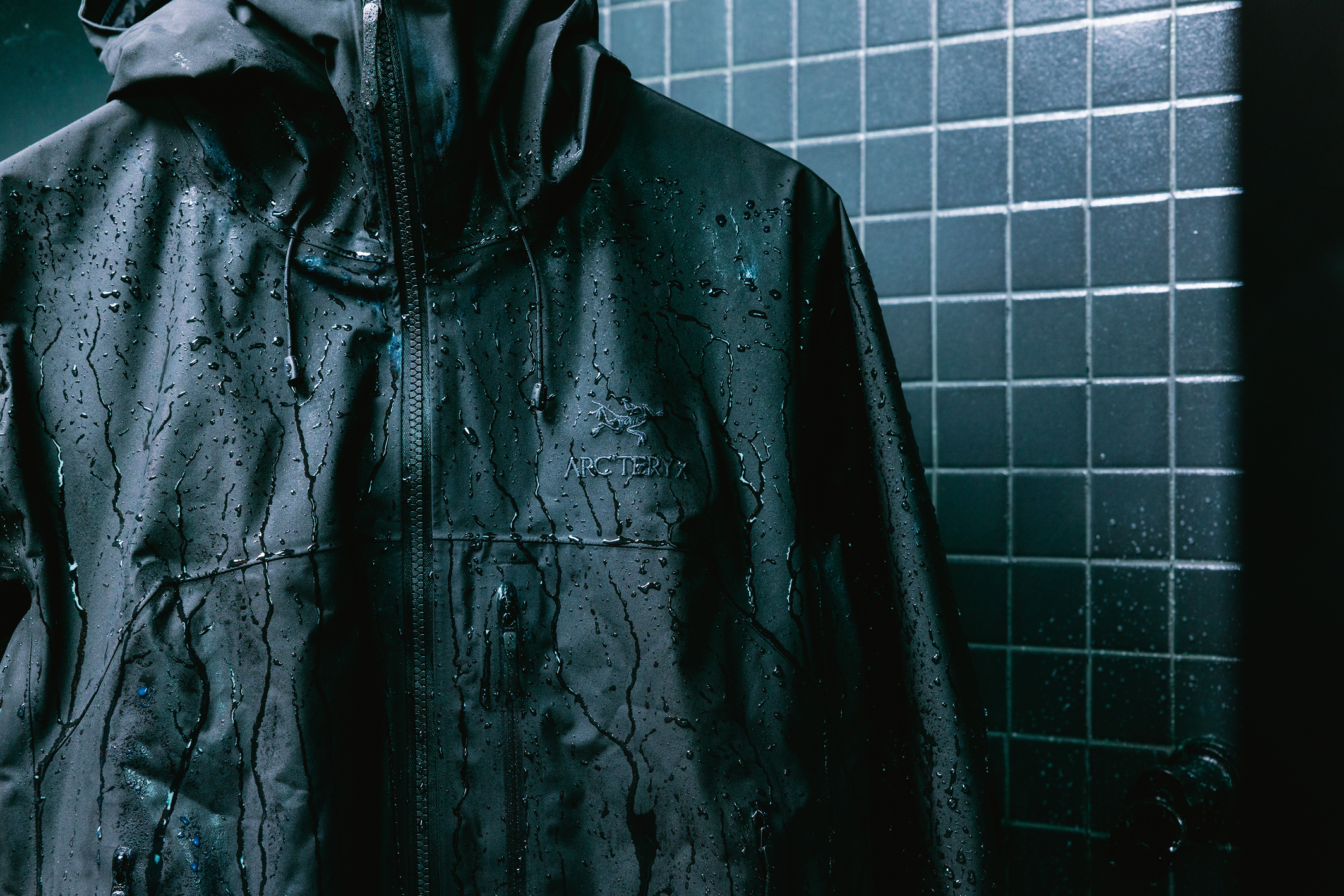 Dark Arc'teryx jacket with water beading on its surface.