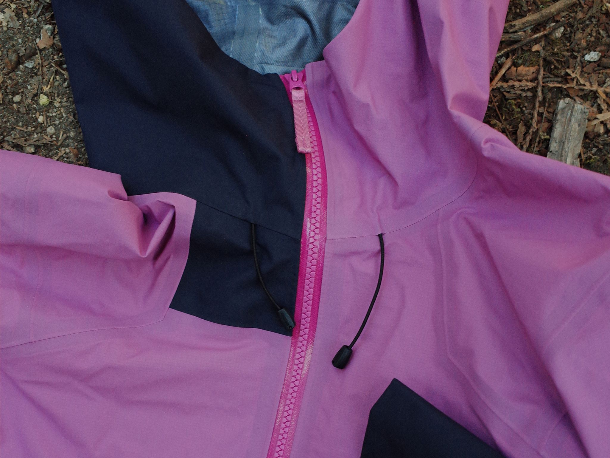 Pink and navy blue jacket with a bright pink zipper and black drawstrings.